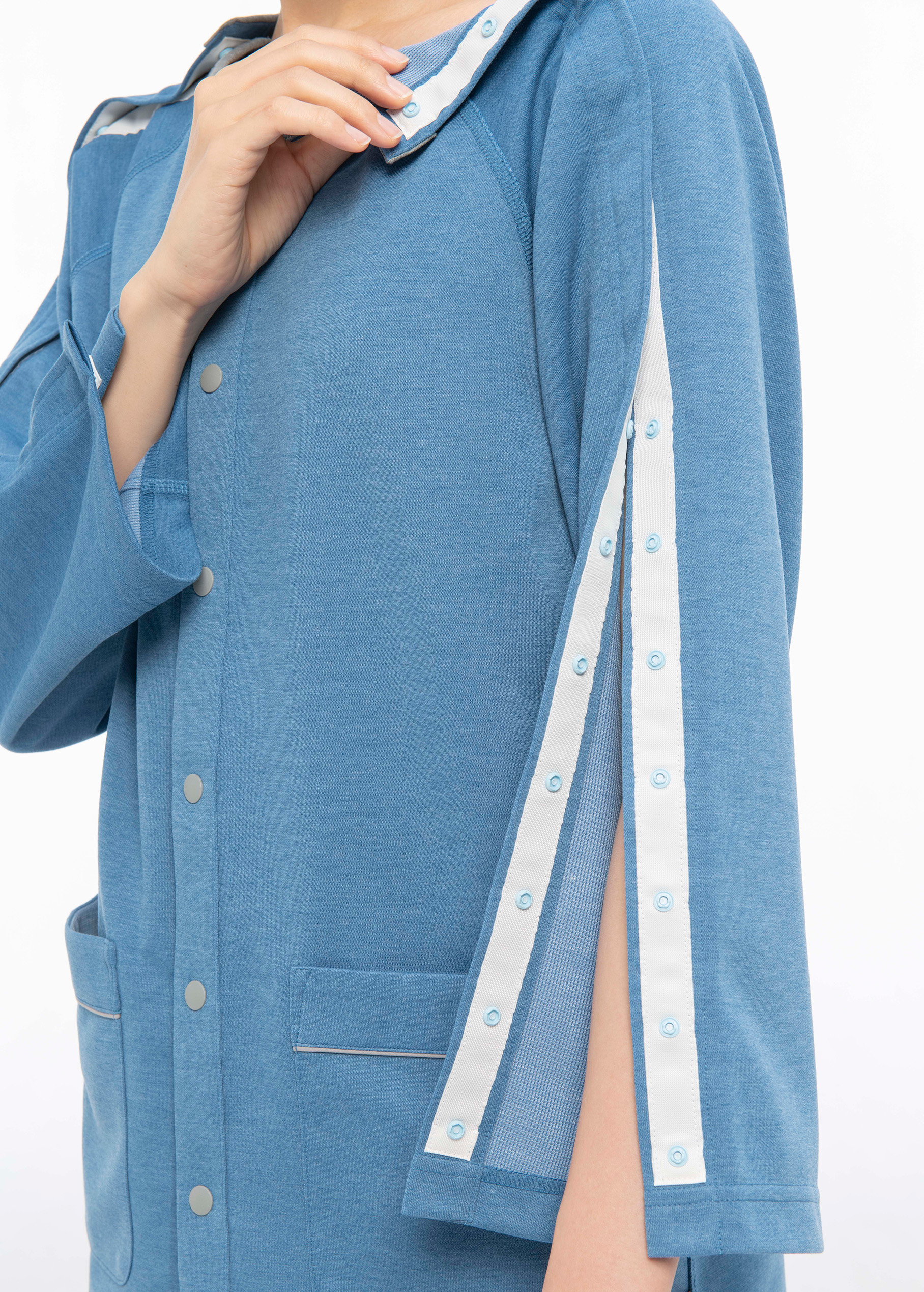 肩から袖にかけてスナップボタンで開きます。